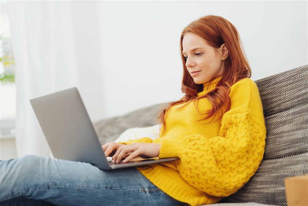 sitting on couch looking at laptop