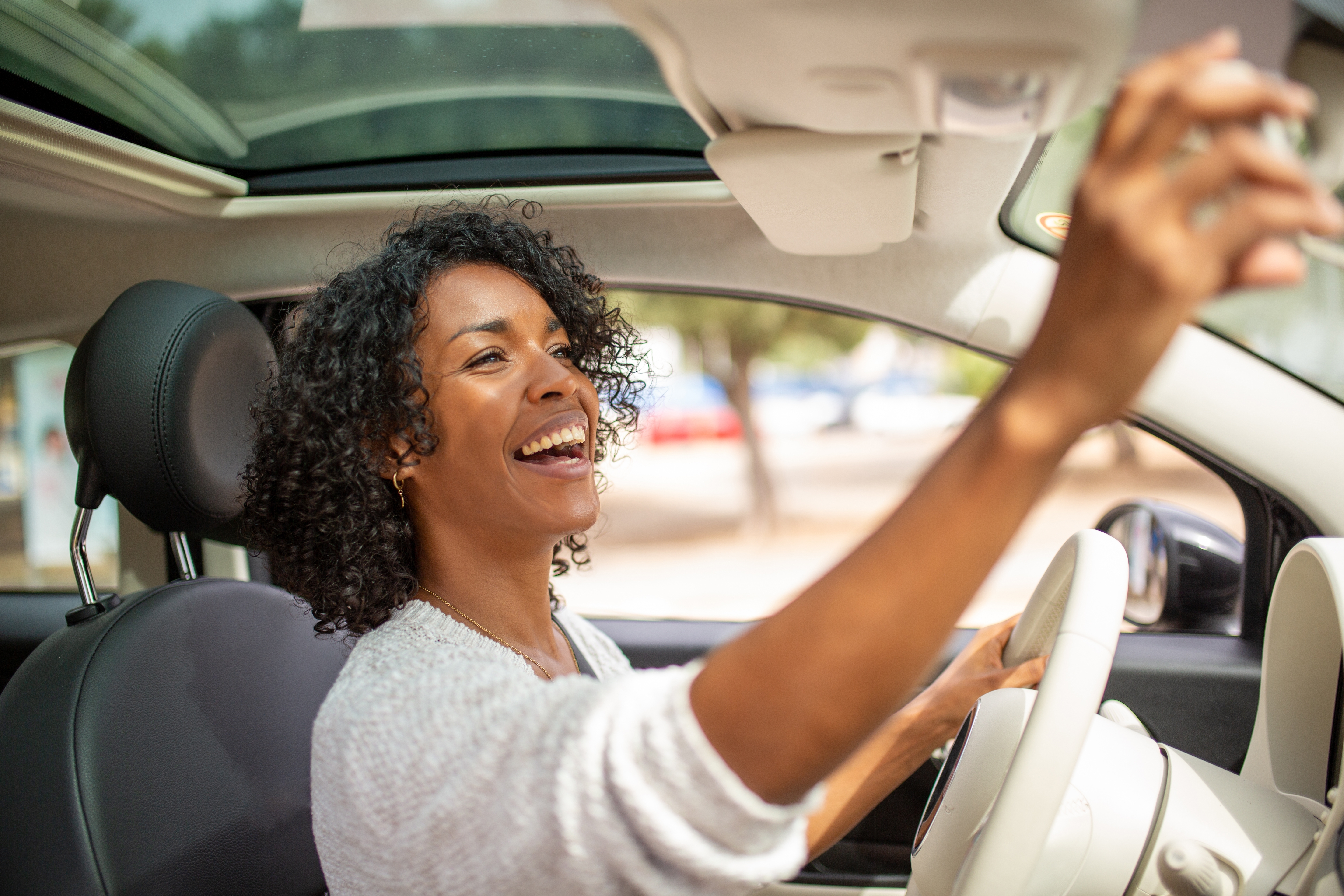 Woman in car looking in rear view mirror