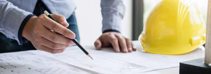 A construction worker looking at blueprints